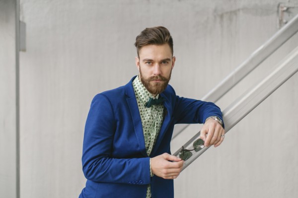 Stylish Middle Eastern man with beard holding sunglasses
