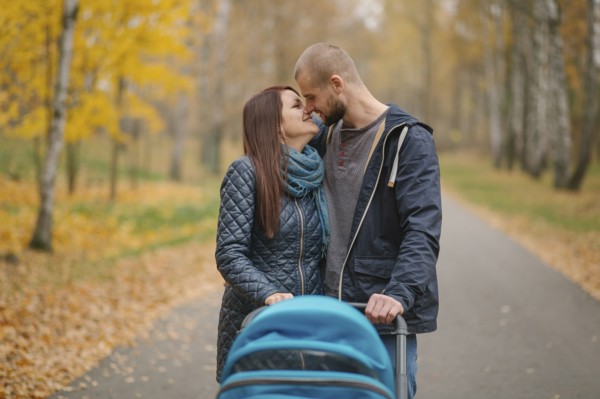 Affectionate Middle Eastern couple with stroller in park