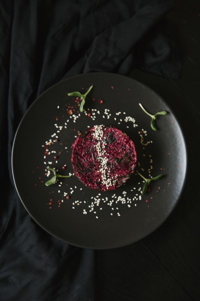 Sesame seeds and garnish on red food on plate