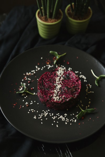 Sesame seeds and garnish on red food on plate