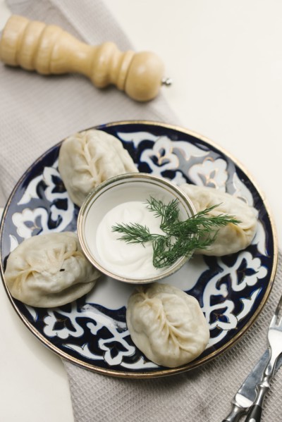 Dumplings and sauce on plate with fork and knife