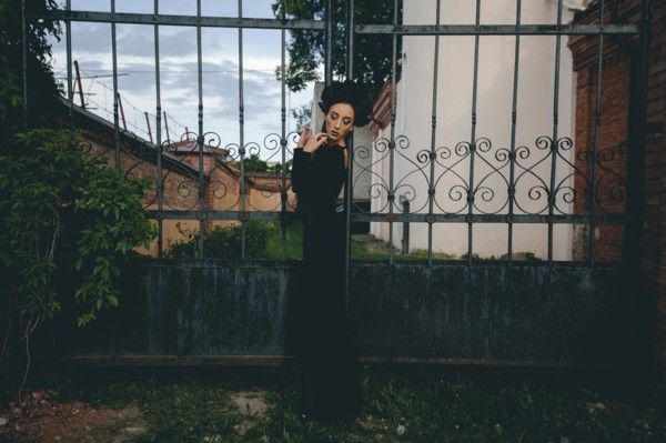 Middle Eastern woman wearing black dress near gate