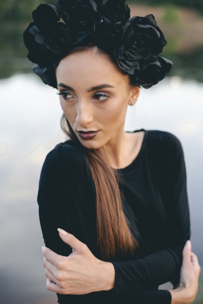 Close up of Middle Eastern woman wearing black dress near lake