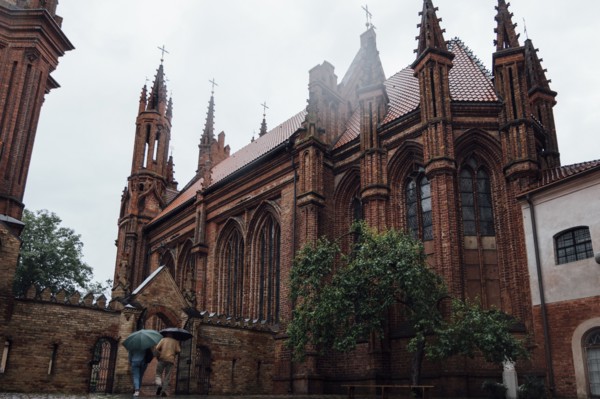 People carrying umbrellas near church