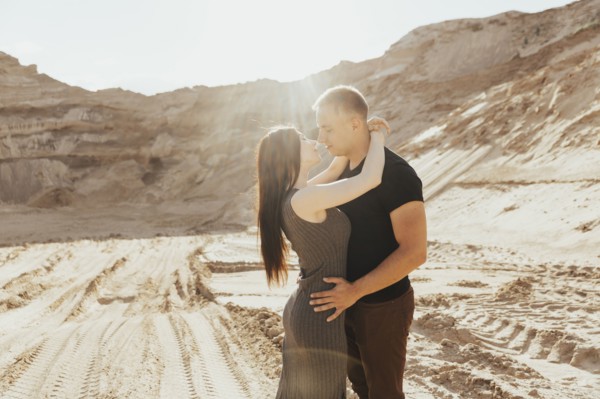 Middle Eastern couple kissing in desert