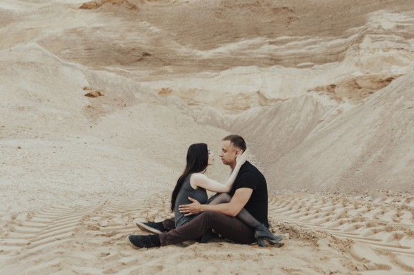 Middle Eastern couple cuddling in desert