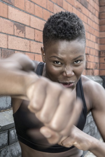 Black athlete punching outdoors