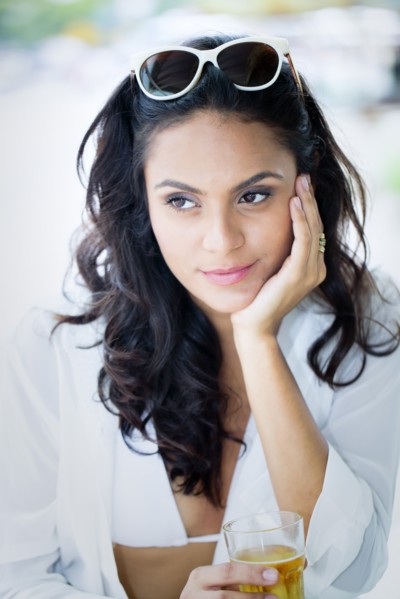 Hispanic woman drinking cocktail outdoors