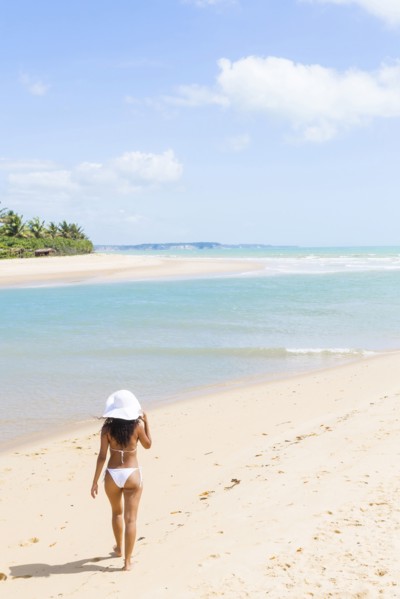 Mixed race woman walking on beach