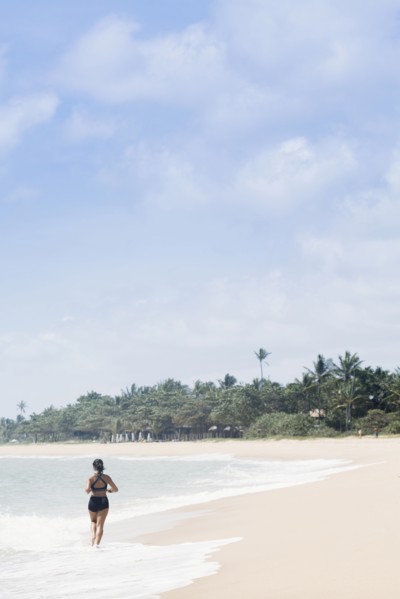 Mixed Race girl running on beach in waves