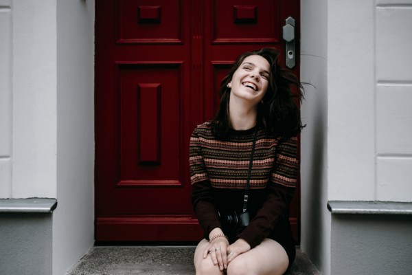 Laughing Caucasian woman sitting in doorway