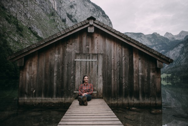 Caucasian woman sitting on dock at remote cabin