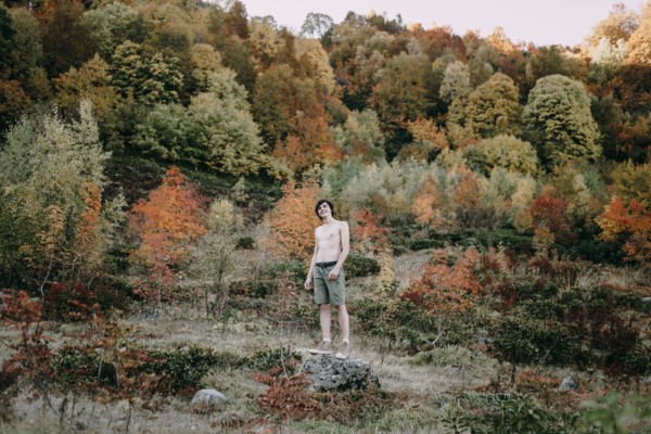 Caucasian man standing on rock in autumn