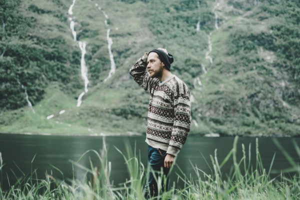 Pensive Caucasian man standing near river