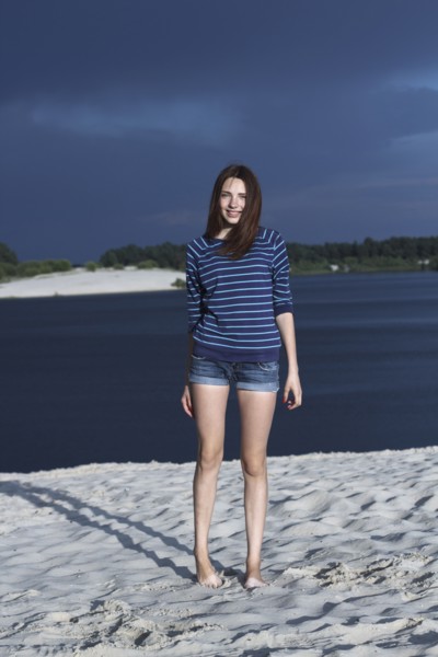 Caucasian teenage girl standing on beach