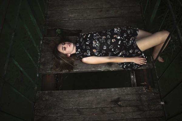 Caucasian woman laying on wooden bridge