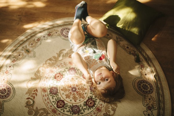 Caucasian boy laying on rug