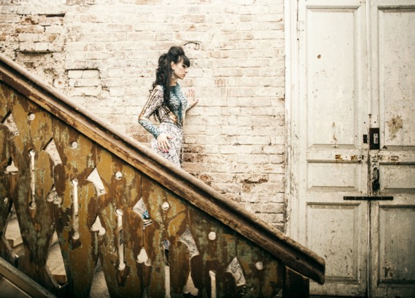 Caucasian woman standing on staircase in dilapidated house