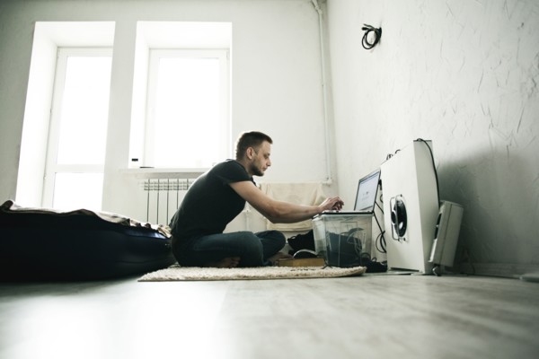 Caucasian man using laptop in bedroom