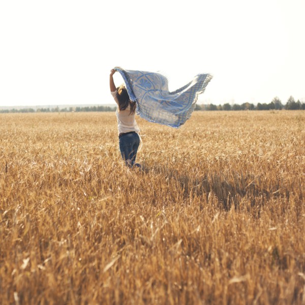 Caucasian woman carrying blanket in rural field