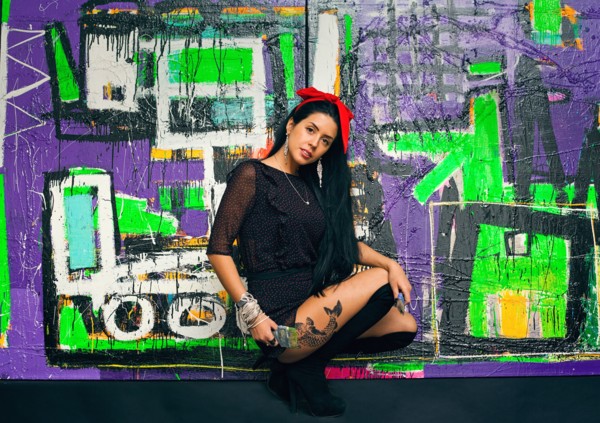Woman posing in front of colorful graffiti wall