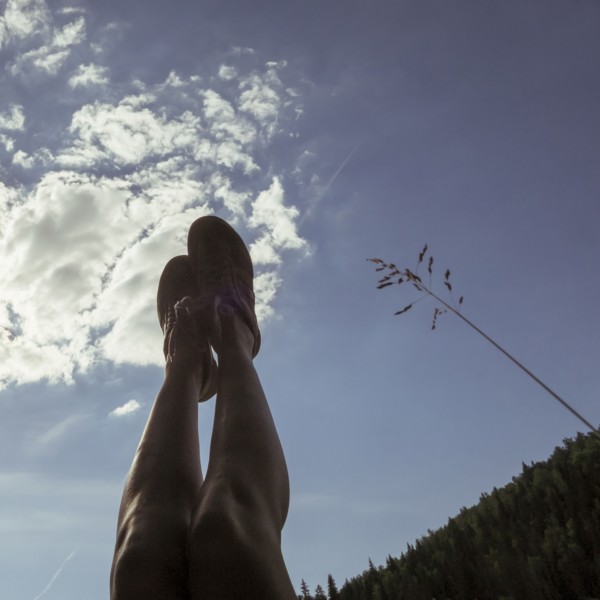 Caucasian with legs raised to blue sky