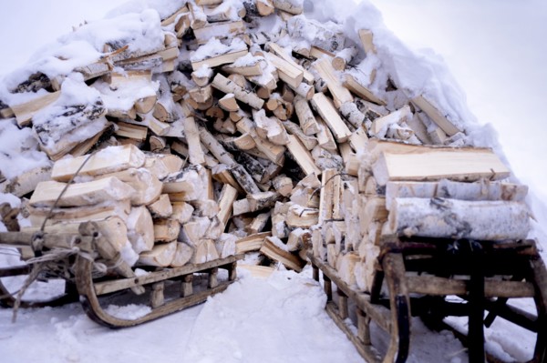 Snow covered firewood on wooden sleds
