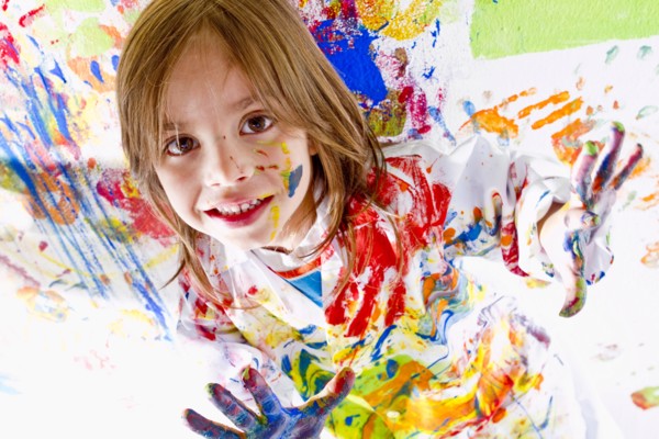 Messy Hispanic girl finger painting
