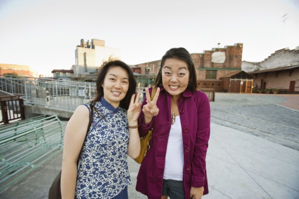 Chinese mother and daughter making peace sign