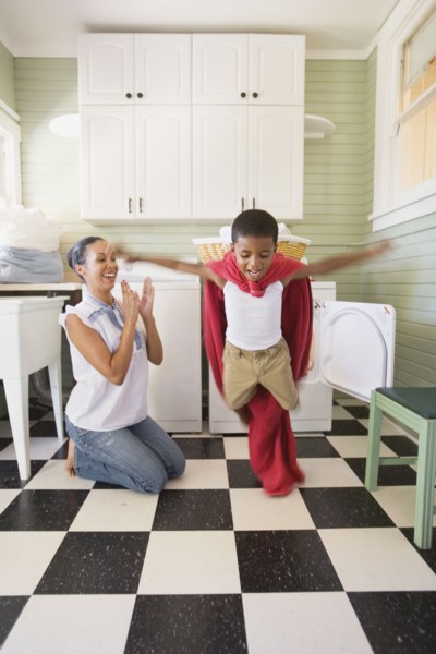 Mixed race mother and son playing with laundry