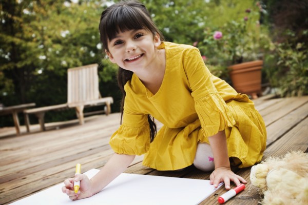 Mixed race girl coloring on deck