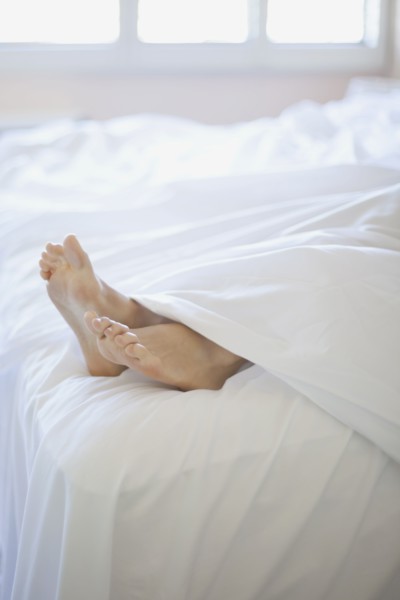 Woman's feet on end of bed