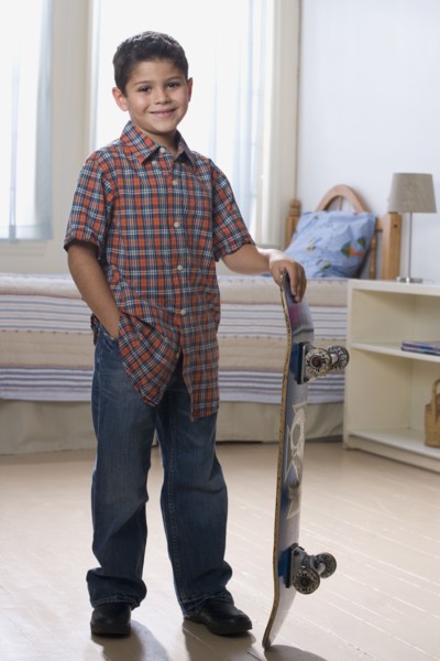 Hispanic boy holding skateboard