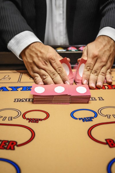 Dealer shuffling cards at baccarat table
