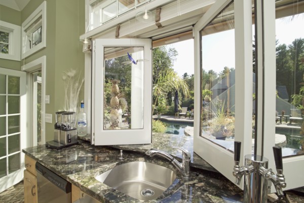 Sink on granite counter by open window in domestic kitchen