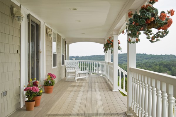 Large front porch of shingle style home with great view of tree tops