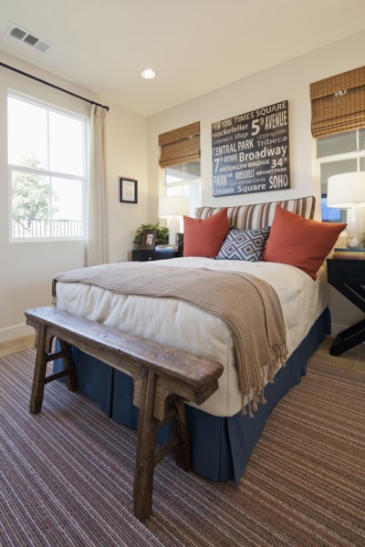 Arranged pillows on tidy bed on carpet floor in the bedroom at home
