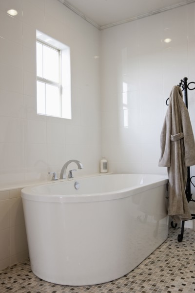 View of a bath with bathrobe on stand in the bathroom