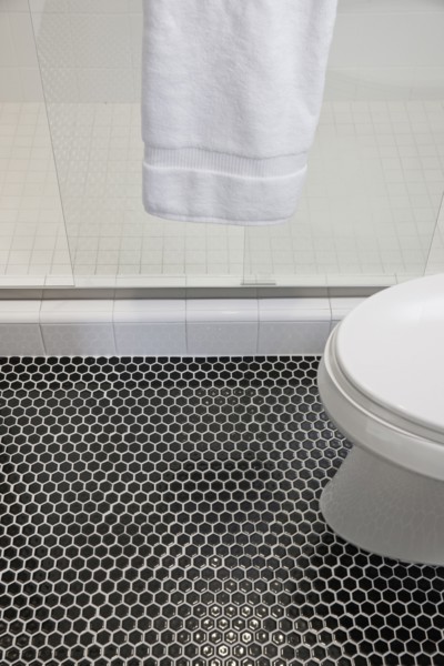 Mosaic floor with cropped commode and glass shower in the bathroom at home
