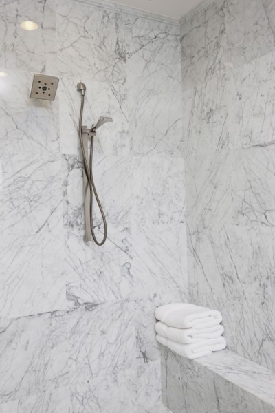Shower head on marble bathroom wall at home
