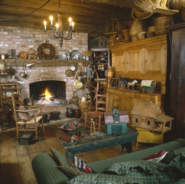 Toy house on coffee table with candle lit chandelier in rustic living room