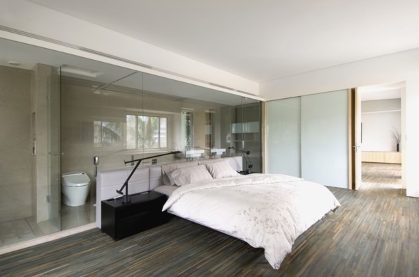 Modern bedroom with glass wall through to bathroom