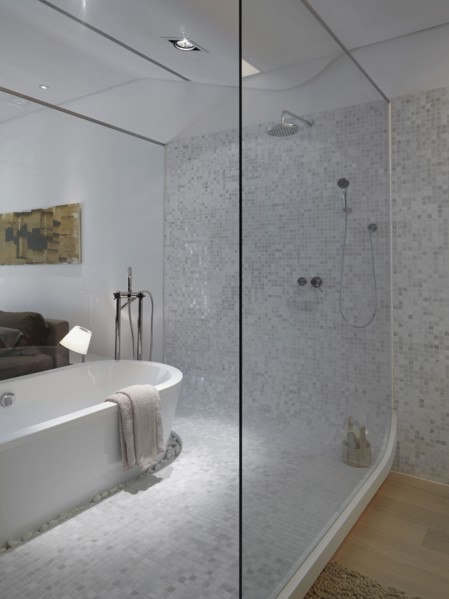 Modern bathroom inside bedroom with glass wall
