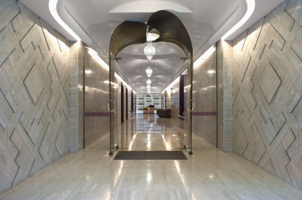 Long marble hallway with double glass doors at end