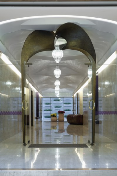 Long marble hallway with double glass doors at end