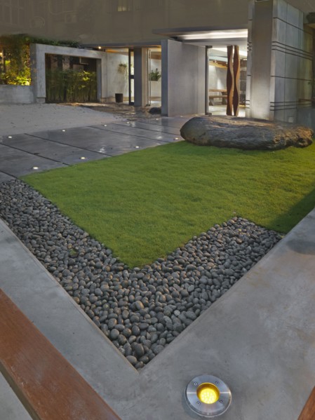 Grass and sidewalk outside front entrance of modern building