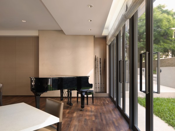 Baby grand piano in corner near double glass doors