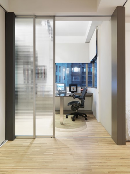 Modern home office with hardwood floor and sliding glass doors