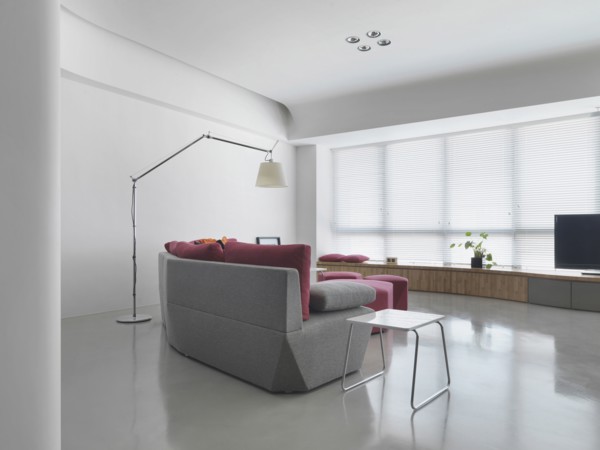 Gray sofa in living room with several windows