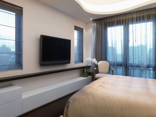 Flatscreen television in modern bedroom